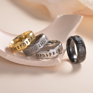 Set de cuatro anillos de runas vikingas en oro, plata y negro con textura martillada