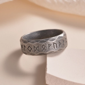 Vista macro de runas vikingas grabadas en un anillo de acero plateado antiguo para hombre
