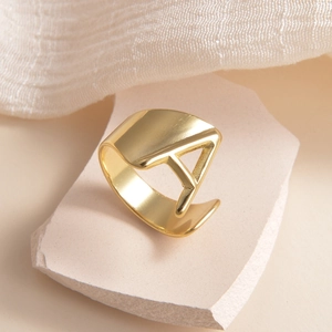 Vue détaillée de la bague réglable en or poli avec un design ajouré de la lettre A