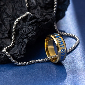 Detailed macro of golden Nordic rune ring featuring blue engraved characters on blue surface