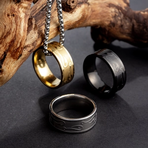 Three-tone fishhook pattern stainless steel rings and box chain on textured stone