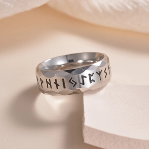 Detailed view of vintage faceted Viking rune ring on a minimalist stone display stand