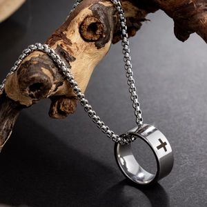 Polished titanium steel cross pendant necklace hanging on a rustic wooden branch