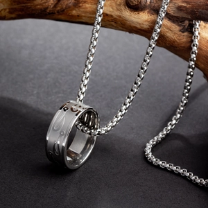 Macro shot of an engraved stainless steel ring pendant on a robust box chain link
