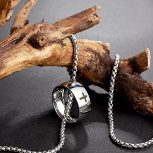 Silver stainless steel cross ring and box chain necklace set on a natural wood branch