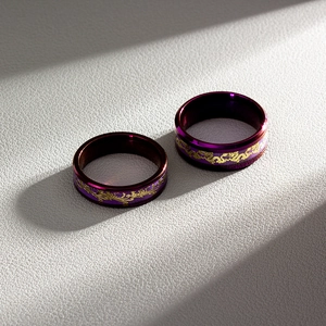 Detail of purple stainless steel couple rings with golden dragon and phoenix patterns