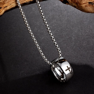 Detailed view of polished silver cross ring pendant on a sleek box chain necklace