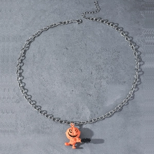 Collier avec pendentif citrouille à tronçonneuse d'Halloween sur fond texturé gris