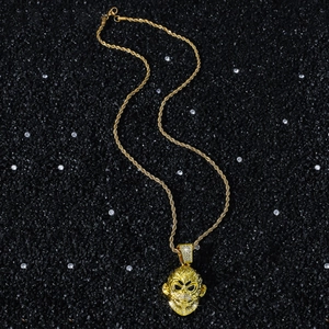 Collier pendentif tête de singe doré avec zircons blancs sur fond de pierre noire