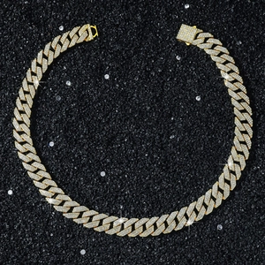 Makroaufnahme einer 15mm Gold-Panzerkette mit Strasssteinen auf schwarzem Kiesboden
