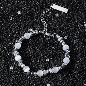 Bracelet en opale hip-hop avec entretoises argentées sur fond de sable noir texturé