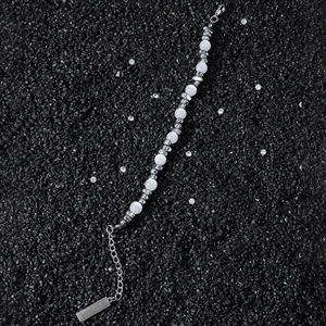 Bracelet perlé hip-hop avec pierres œil-de-chat blanches et perles argentées sur fond noir