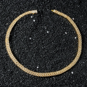 Macro view of gold plated iced out V-shape link chain necklace with sparkling crystals