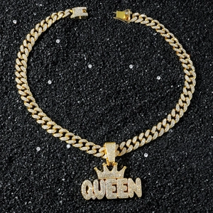 Makroaufnahme einer goldene Hip-Hop-Panzerkette mit Iced-Out-Krone und QUEEN-Anhänger