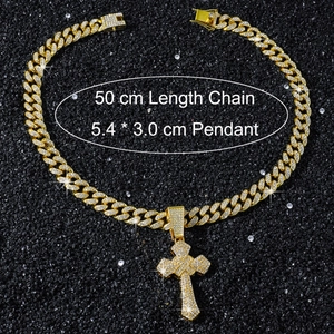 Détail du pendentif croix dorée serti avec chaîne cubaine de 50cm sur sable noir