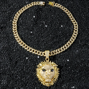 Gros plan du pendentif tête de lion avec cristaux et chaîne cubaine dorée de luxe
