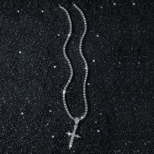 Hip hop tennis chain necklace with iced out thorn cross pendant on a dark glitter background