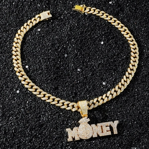 Détail macro du pendentif MONEY serti de cristaux sur une chaîne cubaine dorée de luxe