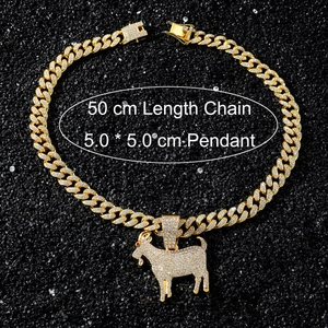 Détail du pendentif chèvre glacé avec chaîne cubaine dorée de 50 cm sur sable noir