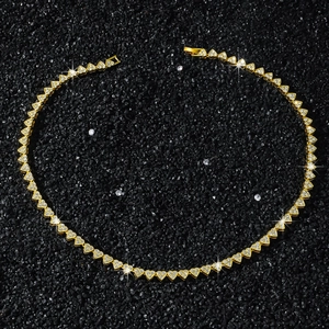 Détail macro du collier à maillons coeur doré avec pavé de diamants sur pierres noires