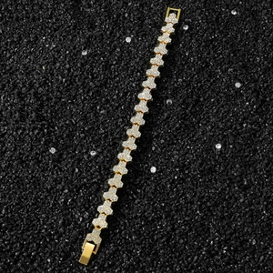 Macro detail of gold hexagon hip hop chain with pave diamonds on black stone