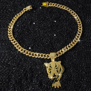 Close-up of golden iced-out cuban chain necklace with micro-paved leopard head pendant