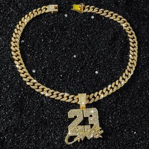 Gros plan sur une chaîne cubaine dorée hip hop avec pendentif numéro 23 et zircons