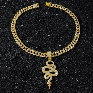 Détail macro du pendentif serpent glacé sur chaîne cubaine dorée sur fond noir