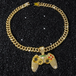Gros plan d'un pendentif manette de jeu hip-hop doré serti de cristaux étincelants