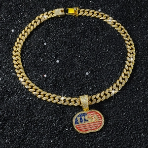 Iced out gold Cuban link chain with USA flag pendant on a dark textured background