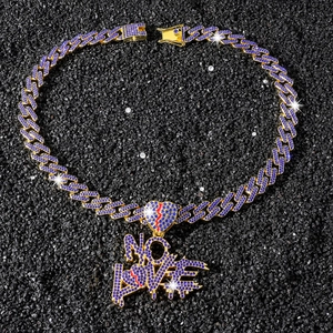 Dettaglio del ciondolo NO LOVE con strass blu su una catena cubana in stile hip hop