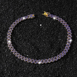 Vue détaillée du collier gourmette plaqué or avec zircons bleus sur fond de pierre noire