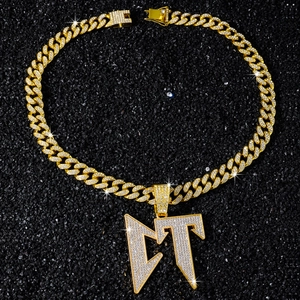 Gros plan sur collier chaîne cubaine dorée hip hop avec pendentif lettre LT brillant