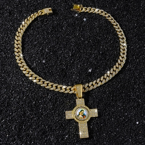 Vue détaillée d'un pendentif croix dorée avec icône de la Vierge Marie et strass
