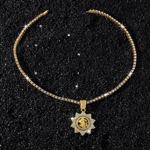 Dettaglio della collana tennis dorata con ciondolo girasole e simbolo del dollaro