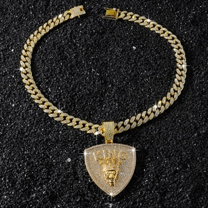 Macro shot of gold hip hop pendant with crown lion head and KING text on black stones