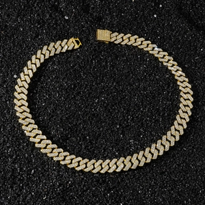 Close-up of a 14mm gold-plated hip-hop chain with pave-set rhinestones on black sand