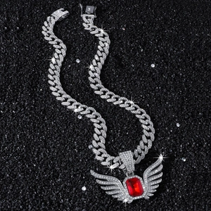 Detail of hip hop angel wing pendant with large red gemstone and full pave diamonds
