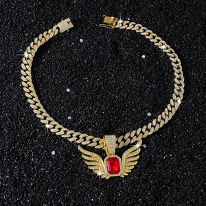 Macro view of gold hip hop necklace with red gemstone and iced out wing pendant
