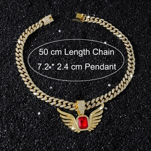 Close-up of gold iced-out necklace with red gem wing pendant and 50cm cuban chain
