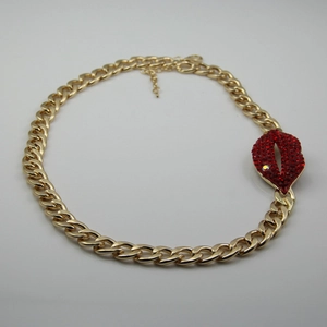 Détail du collier à maillons cubains dorés avec pendentif lèvres en strass rouges et chaîne