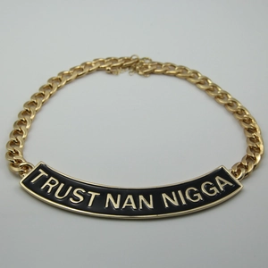Détail du collier à grosse maille gourmette dorée avec plaque slogan Trust Nan Nigga