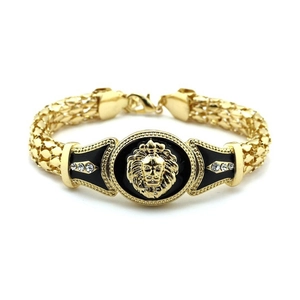 Macro detail of lion head medallion with black enamel and crystals on gold mesh chain