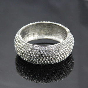 Détail d'un large bracelet en alliage argenté serti de strass brillants pavés