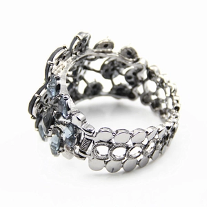 Exaggerated silver-tone wide cuff bracelet with dark grey crystals and openwork dots