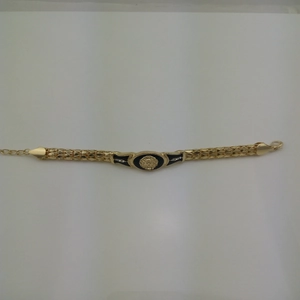 Detail of gold snake chain bracelet featuring black enamel lion head and clear rhinestones