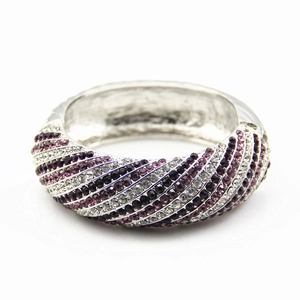 Detail of wide alloy bracelet with rows of purple, black, and white crystal rhinestones
