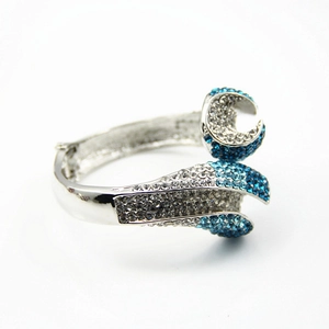 Détail d'un bracelet en alliage argenté avec cristaux bleus et blancs et design ouvert