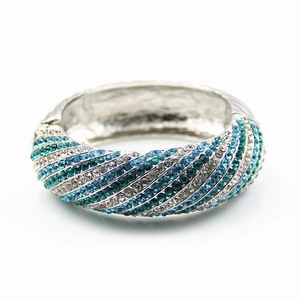 Detailed macro view of wide cuff bracelet featuring spiral rows of blue and white crystals