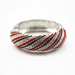 Detailed macro view of a wide bangle with alternating red and white pavé-set rhinestones